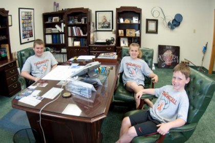 Standing Strong, Walking the Walk Along a “C Word” Journey The McCall kids take "big daddy's" chair at the office